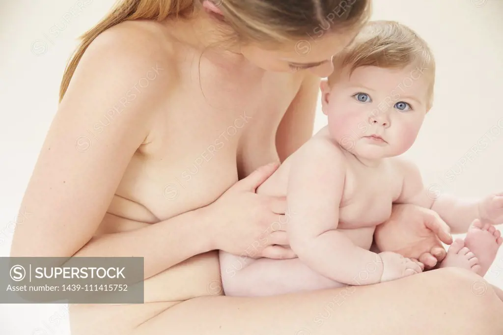 Naked Mother Bonding With Naked Baby On Lap Stock Photo Dissolve Hot