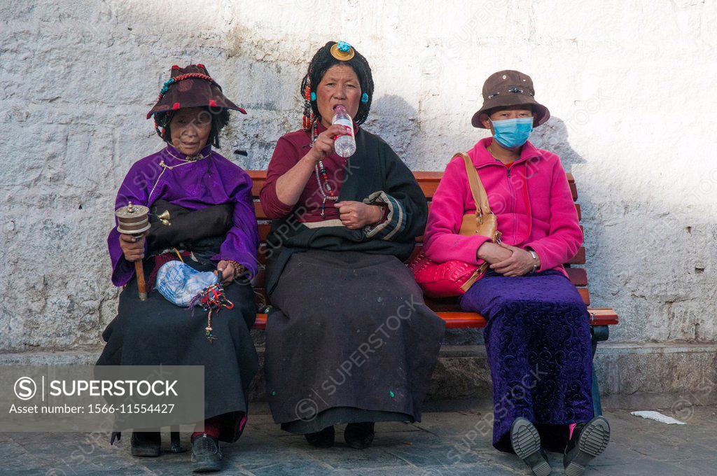 Three Tibetan Women Pilgrims Resting Along The Barkhor Circuit In Lhasa