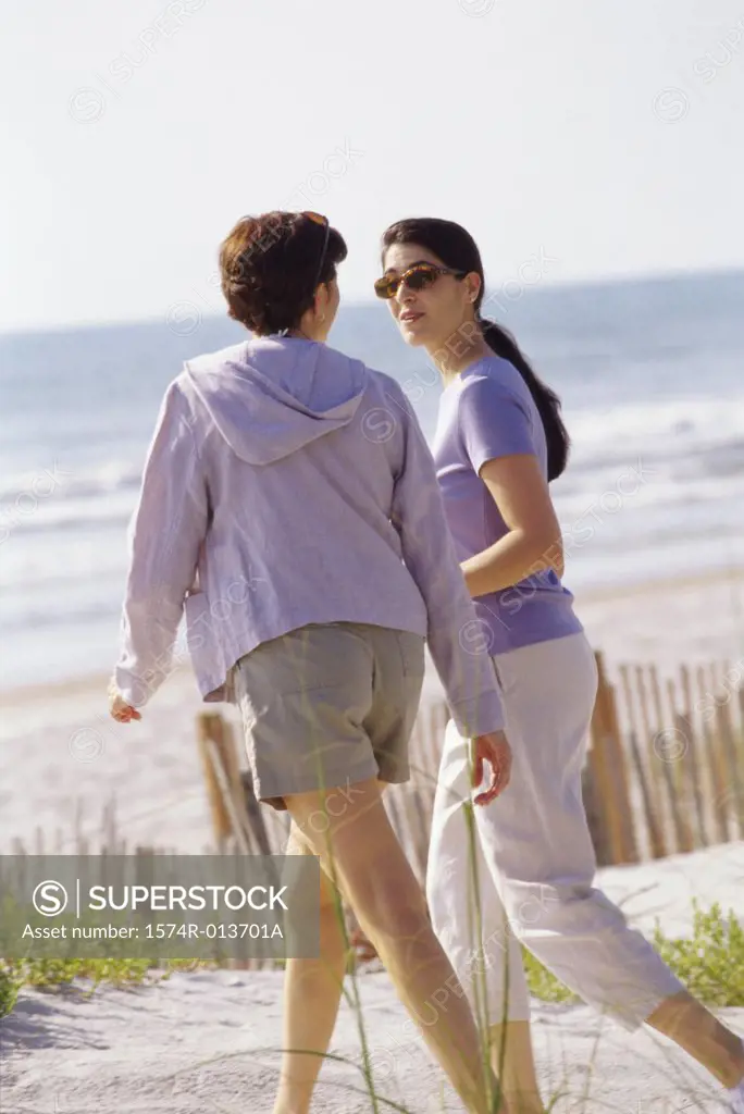 Rear View Of Two Mid Adult Women Walking On The Beach SuperStock