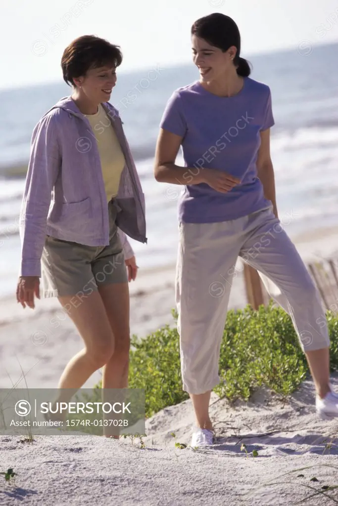 Two Mid Adult Women Walking On The Beach SuperStock