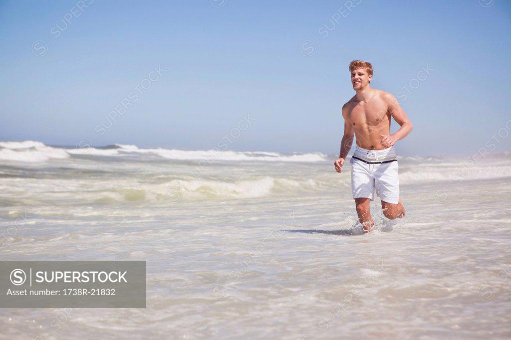 Man Running Shirtless On The Beach Superstock