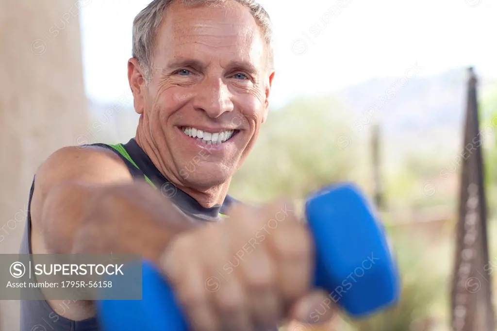 Portrait Of Senior Man Lifting Dumbbells Superstock