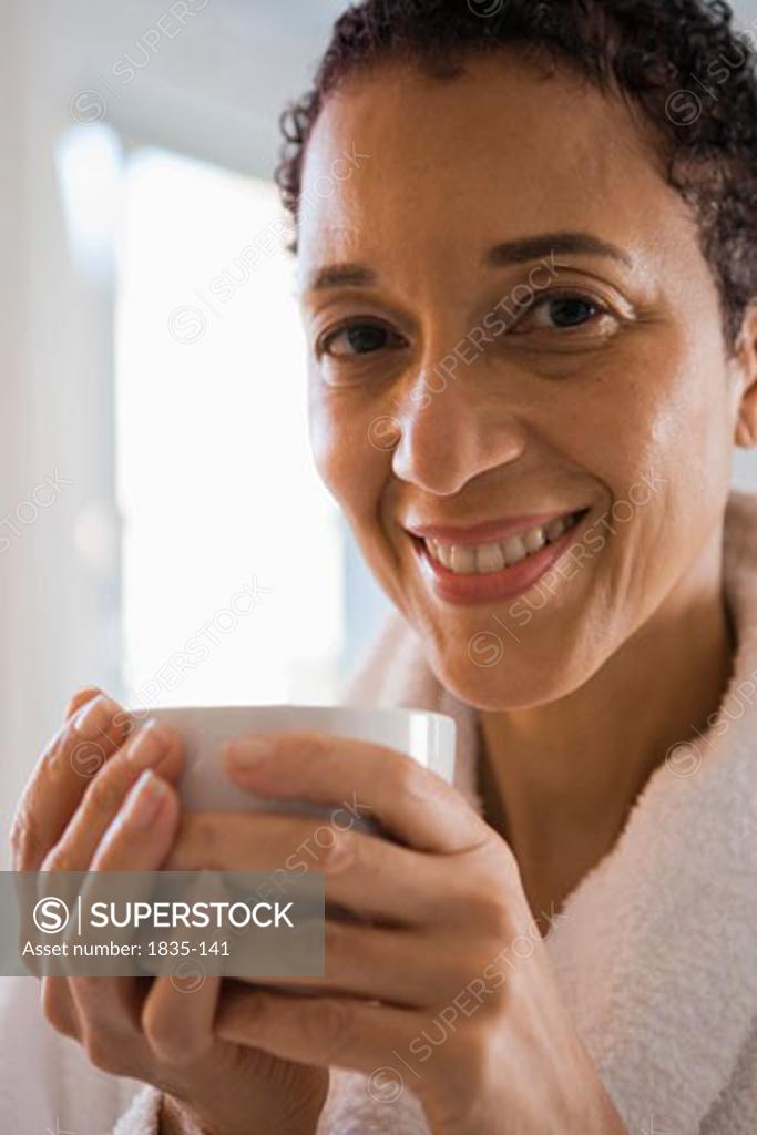 Portrait Of A Mature Woman Holding A Cup Of Coffee And Smiling SuperStock