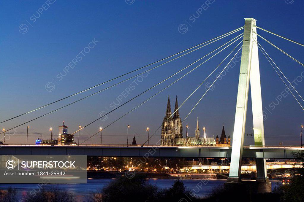 Suspension Bridge Across River With Church In Background