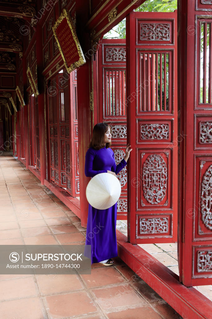 A Woman In A Traditional Ao Dai Dress And Non La Conical Hat In The