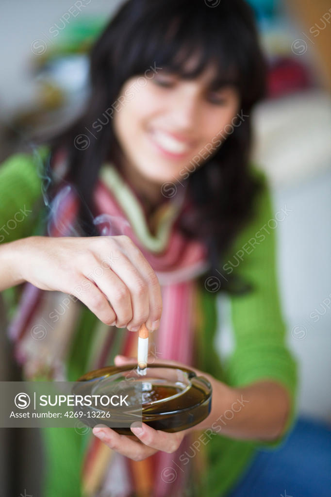 Teenage Girl Stubbing Out Cigarette SuperStock