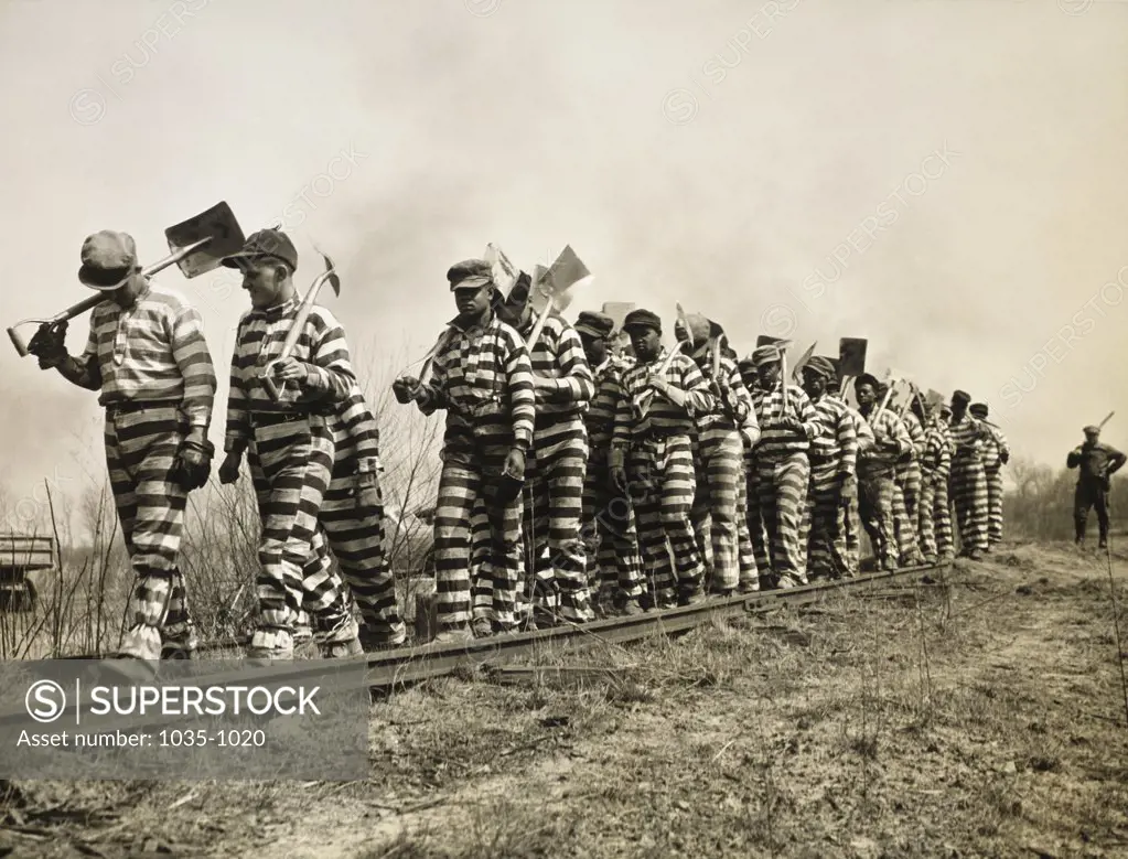 Prisoners walking on a railroad track with shovels, Georgia, USA, 1937