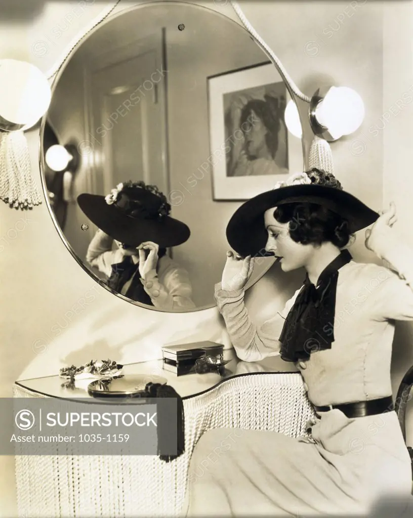 Side profile of a young woman sitting in front of a mirror