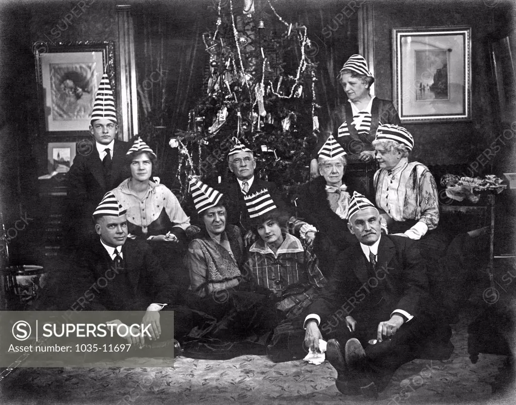 United States:  c. 1915. A family with an interesting Christmas tradition of strange hats and weird expressions.