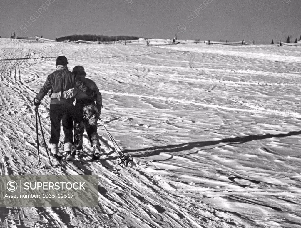 St. Sauveur, Quebec, Canada:  c. 1952. A weary and happy couple head home arm in arm  after a day of skiing.