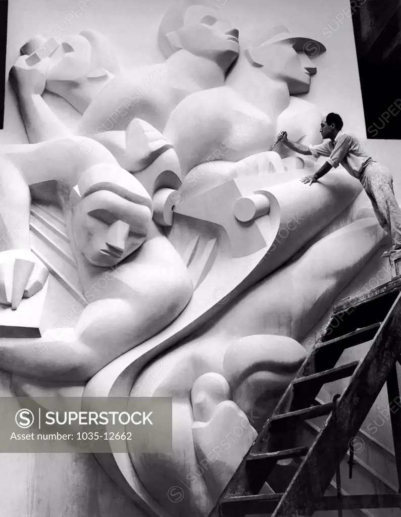 New York, New York:  1940 Isamu Noguchi working on the Associated Press Building Plaque, which was carved in plaster and cast in stainless steel - at that time the largest-ever stainless steel casting.  It is still installed in Rockefeller Center.