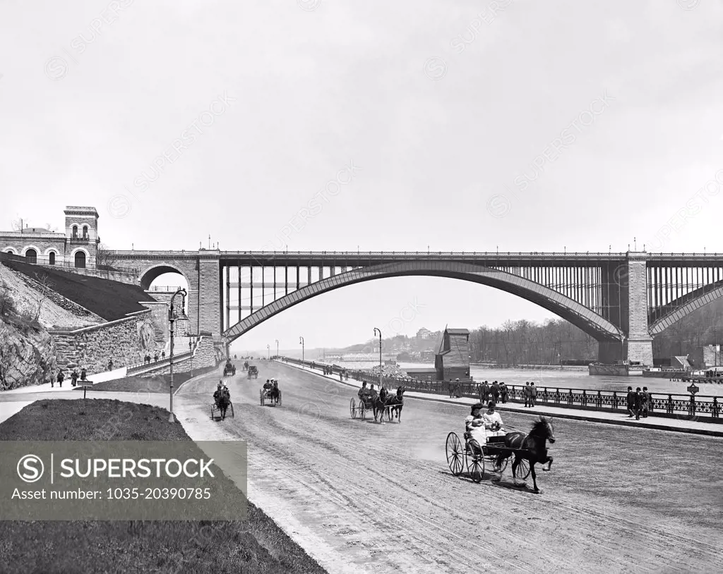 New York, New York:  c. 1901 A view of the Harlem River Speedway with the Washington Bridge in the background. It was initially open only to carriages and sulkies so the wealthy could parade their trotting horses down the 2.5 mile dirt roadway. Pedestrians, horseback riders, and cyclists were prohibited.