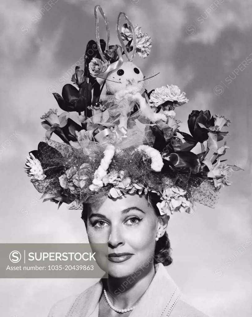 United States:  c. 1950 A portrait of an elegant woman wearing a large Easter bonnet.