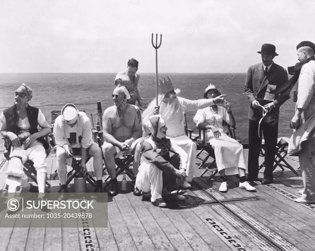 Pacific Ocean:  October 15, 1942 The court of Neptunus Rex, Ruler of the Raging Main, convenes on the deck of a U.S. Navy aircraft carrier as it approches the equator. The court will go into action to convert the "pollywogs" (men who have never crossed the equator) into "shellbacks" once they have completed the rituals.