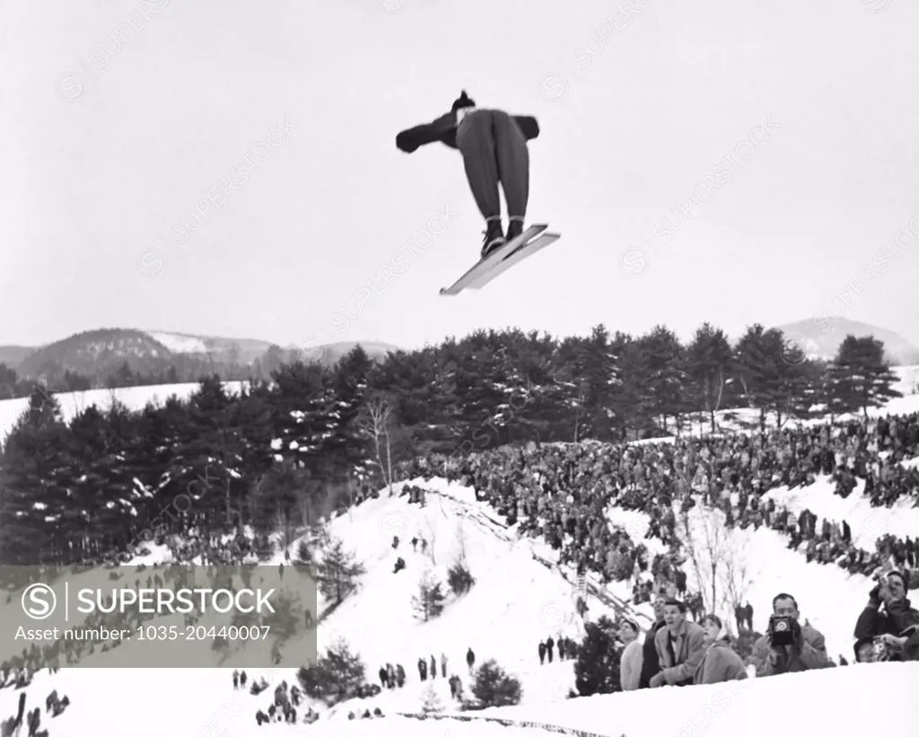 Hanover, New Hampshire:  c. 1955 A back view of a skier going off the ski jump at the annual Winter Carnival of the Dartmouth Outing Club.