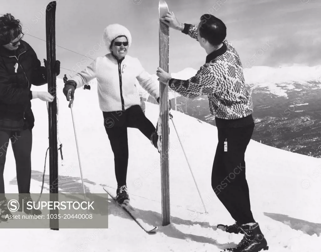 Jasper National Park, Alberta, Canada:  c. 1963 Two women wax their skis before the run down the ski trail.