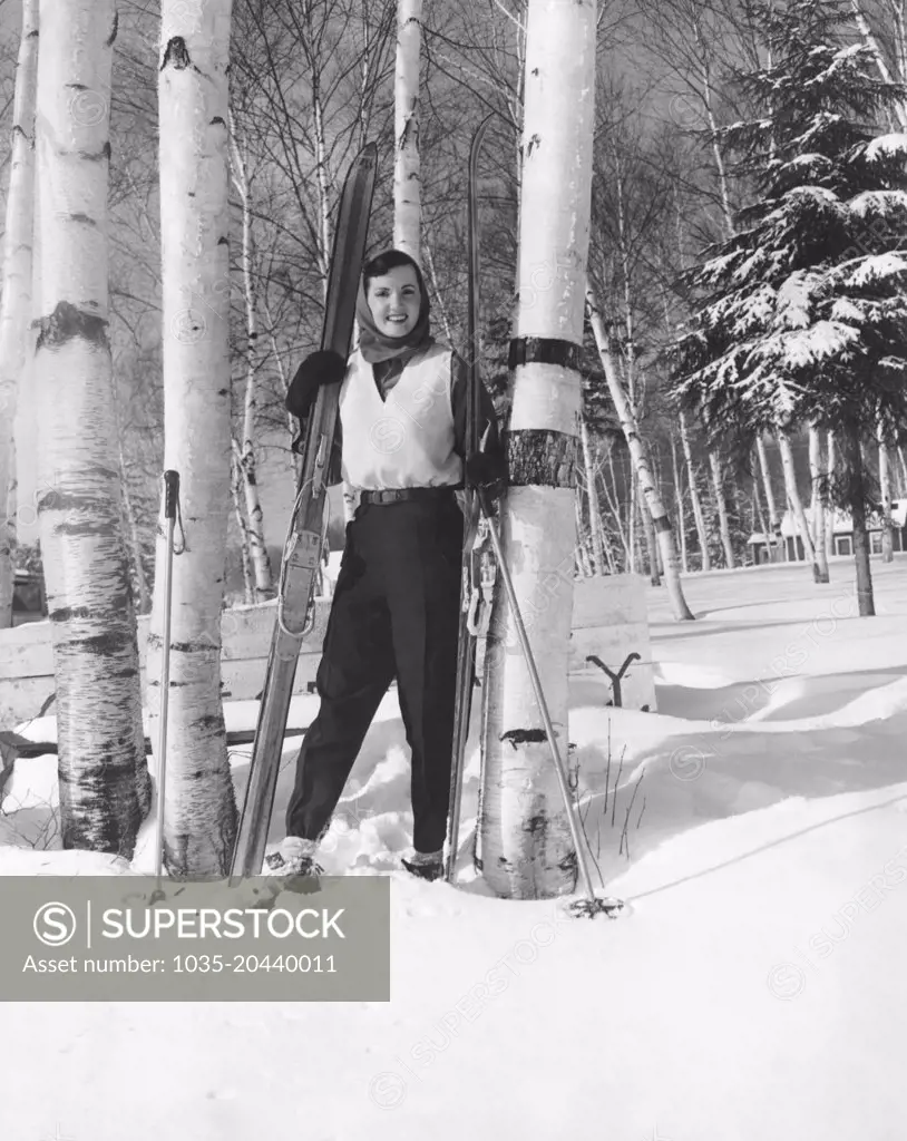 Lake Of Bays, Ontario, Canada:  c. 1956 A young woman with her cross country skis standing in a grove of birch trees.