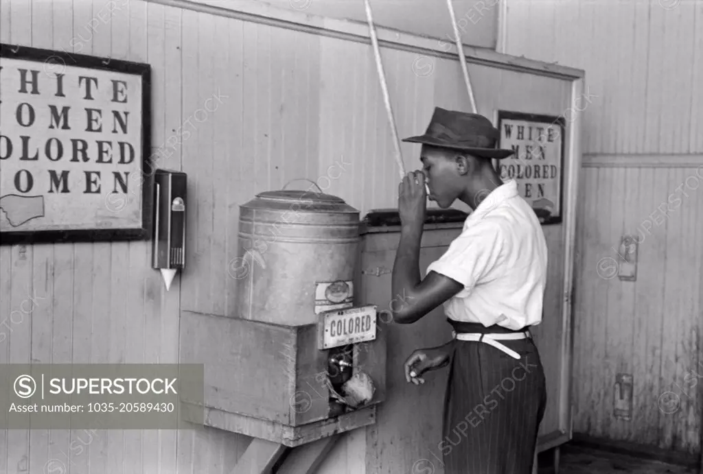 Oklahoma City, Oklahoma:  July, 1939 A Negro drinking at "Colored" water cooler in a streetcar terminal,