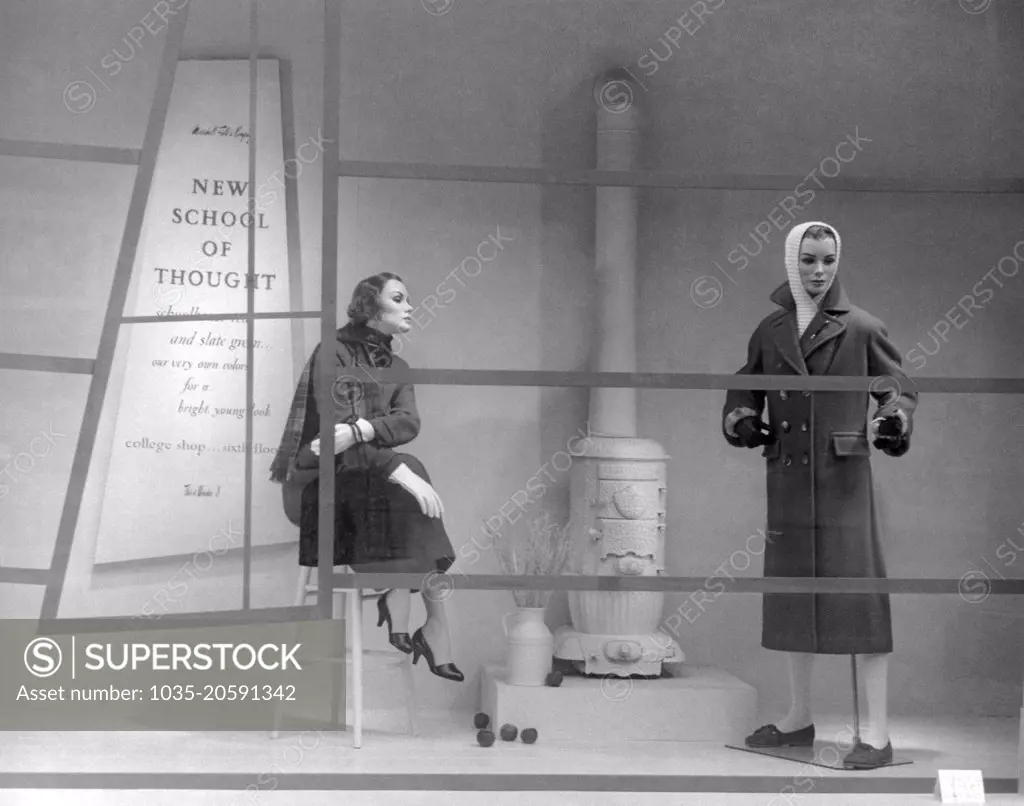 Chicago, Illinois:  August 11, 1956 A Marshall Field's department store window display during State Street Days showing the "New School of Thought" for college shoppers in compariosn with the bygone days as evidenced by the old coal burning heater.