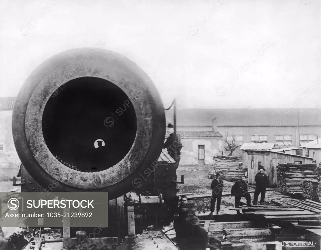 United States:  April 24, 1919 Looking down the muzzle of a 14 inch gun mounted on a railway car that is of the sort that is used against the Germans. A soldier can be seen on the other end, sixty feet away.