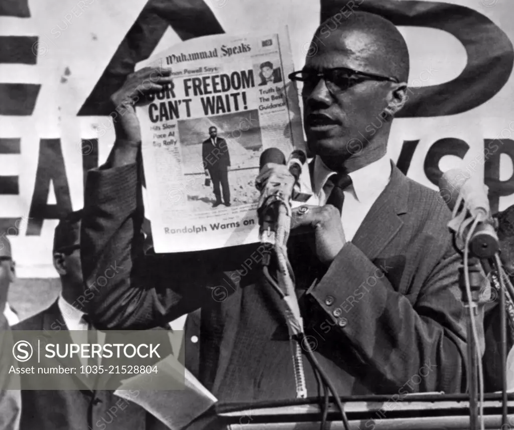 New York, New York:  July 27, 1963   "Malcolm X, Black Muslim leader, holds up paper for the crowd to see during Black Muslim rally in New York City. In their rallies the Muslims, an African Nationalist organization, preach a philosophy of "hate the white man". The Black Muslims are one of the extremest groups within the Negro community.". The above is the original caption from the Associated Press for the photograph which was to run on August 5th with an article by Junius Griffin.