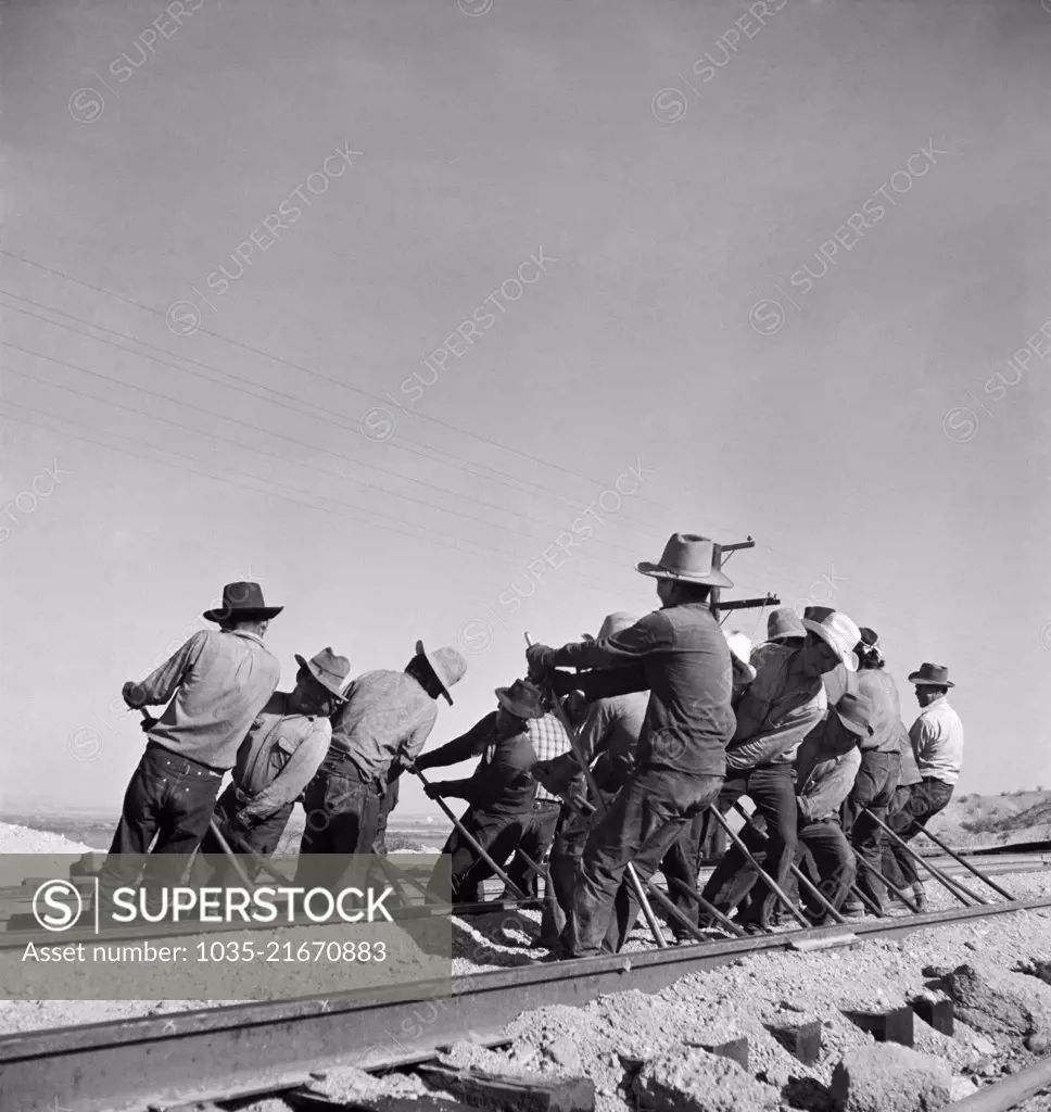Needles, California: March, 1943 An Indian section gang at work on the tracks in the Atchison, Topeka and Santa Fe Railroad yards.