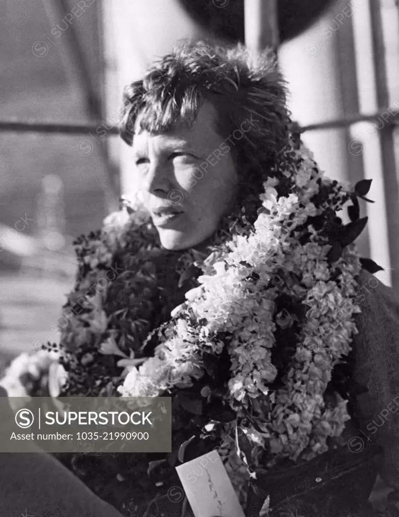 Honolulu, Hawaii: December 27, 1934 A closeup of the country's most outstanding woman flyer, Amelia Earhart Putnam as she arrives on her first visit to the Territory of Hawaii and is greeted by her admirers with floral leis.