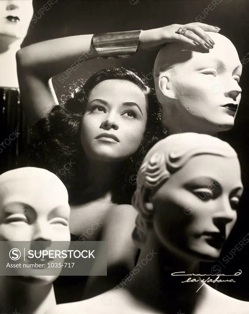 Close-up of a young woman posing with mannequins