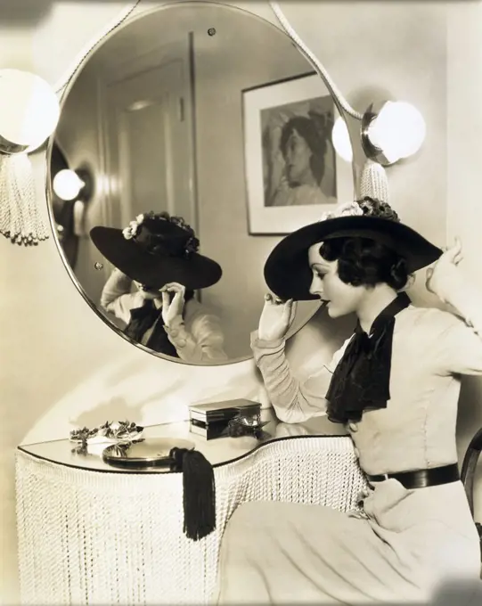 Side profile of a young woman sitting in front of a mirror