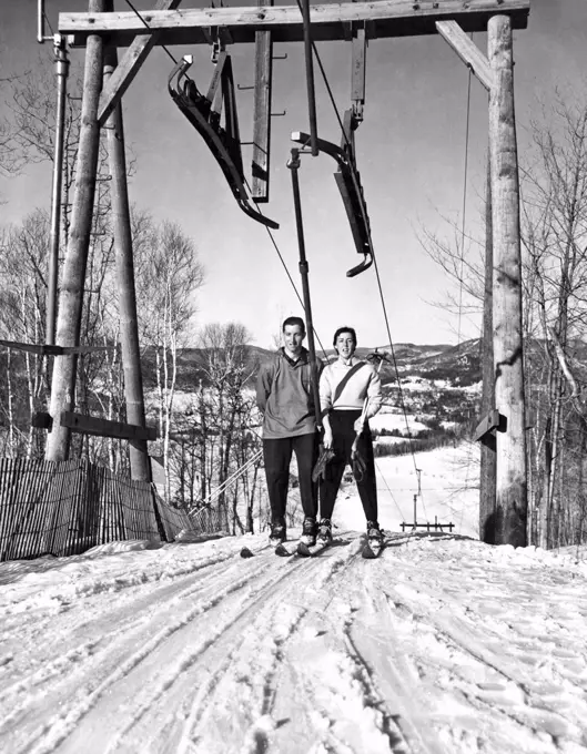 Saint-Sauveur, Quebec, Canada:  c. 1953. A lovely day on the slopes as this couple breeches the top of the slope before a run back down the mountain.