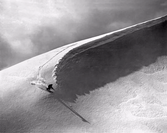 Lake Louise, Alberta,  Canada:  c. 1951. A skier cuts under a snow curl in the Rocky Mountains.