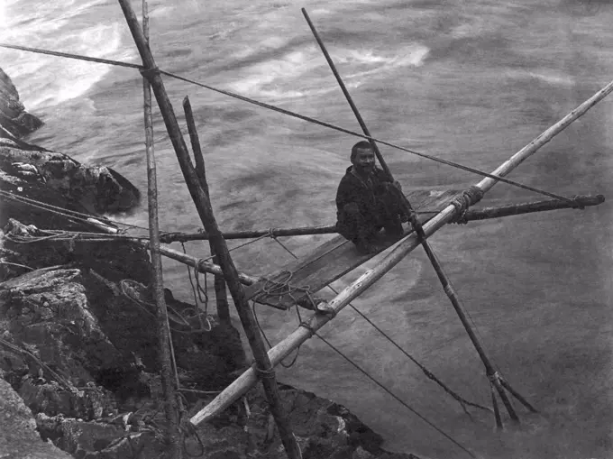 Kamloops, British Columbia, Canada:   c. 1900. A Kamloop Native American man fishing for salmon on the Fraser River.