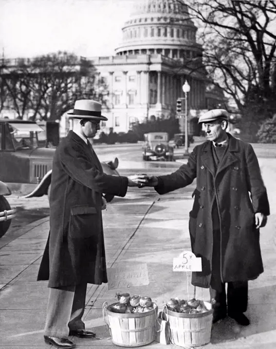 Washington, D.C.:   1930. Congressman Fred Hartley Jr. of New Jersey buys an apple from one of the unemployed apple vendors in Washington.