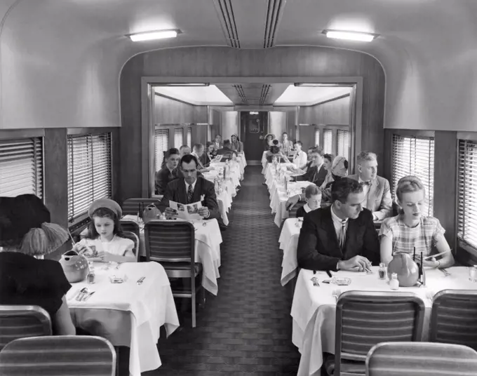 United States:  c. 1940. Passengers on a train in the dining car for dinner.