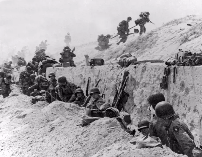 Normandy, France:  June 9, 1944. American troops of the 4th Infantry Division at Utah Beach taking a breather before continuing the assault over the hill to the interior of France.