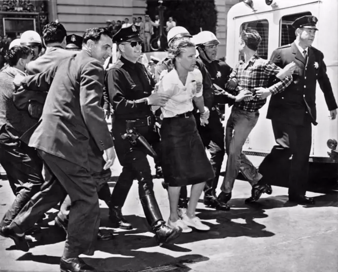 San Francisco, California:  March 1, 1961. Three wet and defiant protesters of the House Un-American Activities Committee hearing at San Francisco City Hall are taken to the paddy wagon Sixty four total college age persons were arrested after being hosed by the police. The HUAC claimed that Communists masterminded the protest.