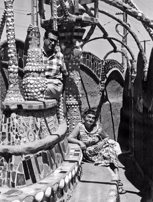 Los Angeles, California: c. 1960. Two visitors at the Watts Towers in the Watts distirct of Los Angeles.