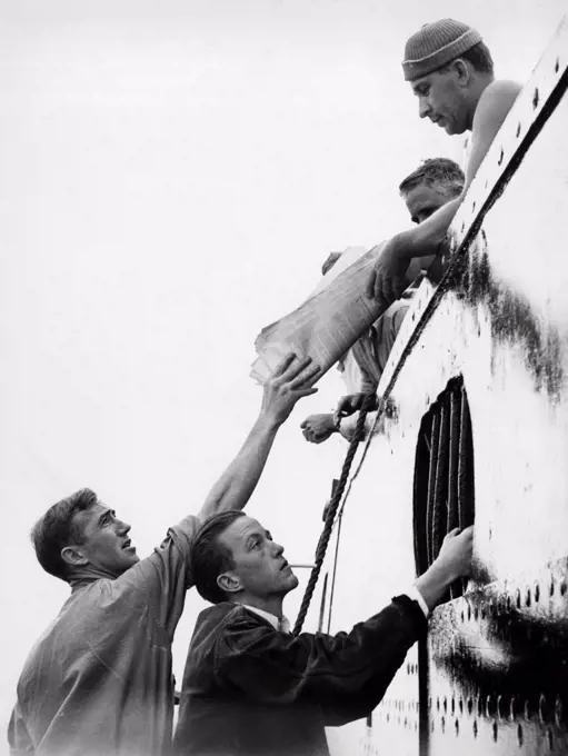 Long Beach, California:  November 12, 1936. Members of the Striking Committee of the International Seamen's Union pass literature to crew members of the Ford freighter, Lake Osweya.