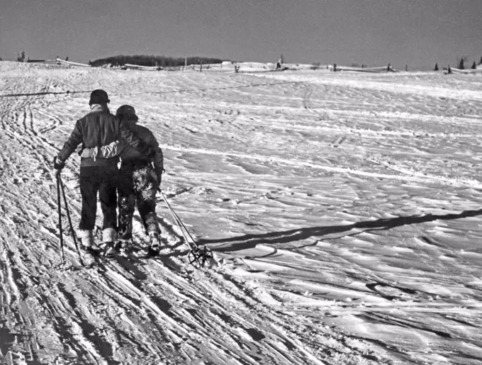 St. Sauveur, Quebec, Canada:  c. 1952. A weary and happy couple head home arm in arm  after a day of skiing.