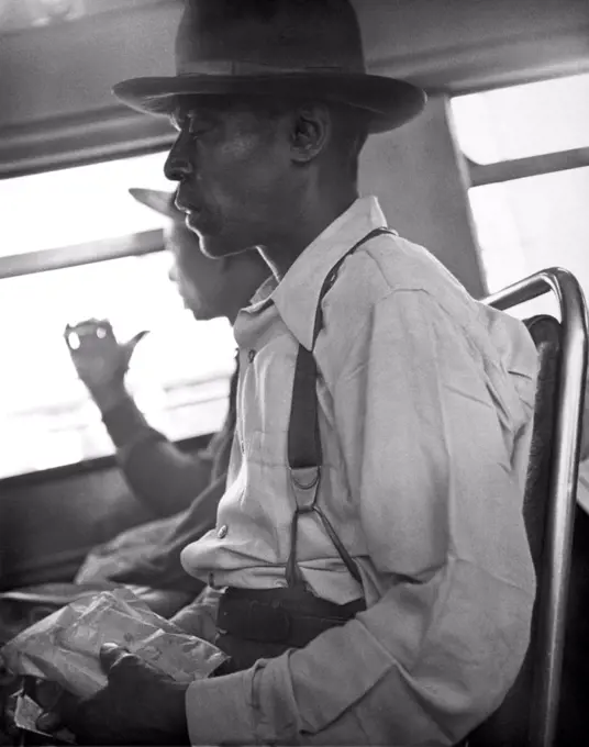 c. 1934 Two black men riding in a bus.