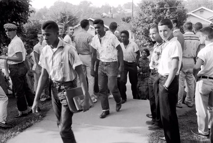 Clinton, Tennessee:  December 4, 1956 A line of African American students walking through a crowd of white boys into the school.