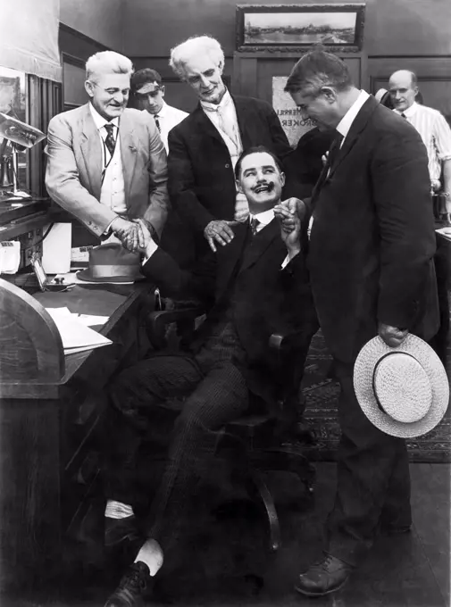 New York, New York:  c. 1917 Sign on the door says 'Merrill Broker', and possibly Charles Merrill. The photograph looks like a film still, but was used in a book on Wall Street and the author identified the seated man as Charles Merrill.....