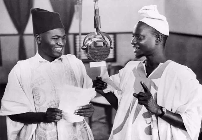 Accra, Gold Coast:  June 17, 1943 Mallam Isq Katsina (L) and Mallam Bello Kano (R) broadcast to British West Africa from the Gold Coast broadcasting station in Accra. They broadcast regularly in their own language, bringing Africans the latest news and entertainment programs. The Gold Coast became indendent in 1957 and is now known as Ghana.