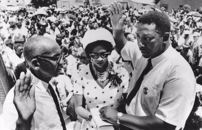 Fayette, Mississippi:   July 7, 1969 Civil rights leader Charles Evers is sworn in as mayor of Fayette, Mississippi by Justice of Peace Willie Thompson. Mrs. Evers holds the Bible for her husband. Charles is the brother of slain rights activist Medgar Evers.