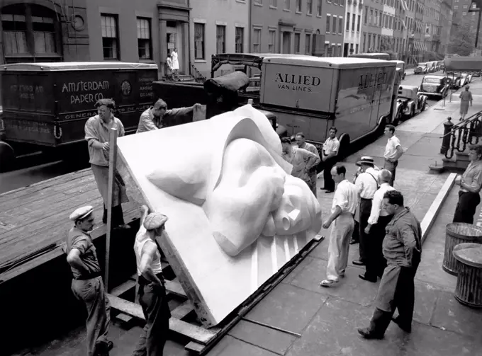 New York, New York:  1940 Isamu Noguchi looking at part of the Associated Press Building Plaque, which was carved in plaster and cast in stainless steel - at that time the largest-ever stainless steel casting.  It is still installed in Rockefeller Center.