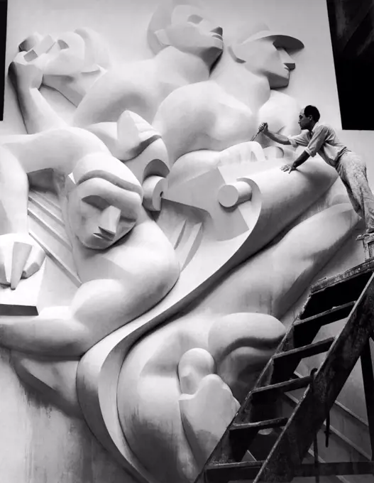 New York, New York:  1940 Isamu Noguchi working on the Associated Press Building Plaque, which was carved in plaster and cast in stainless steel - at that time the largest-ever stainless steel casting.  It is still installed in Rockefeller Center.