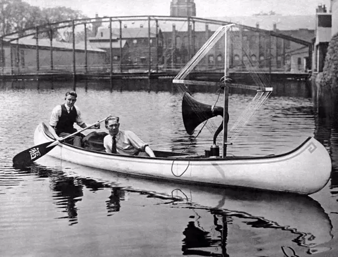 New York, New York:  July 22, 1922 These ingenious radio fans have rigged their canoe with an amplifier and aerial to hear music on the water. They can now have music wherever they are and have no such trouble as winding up a phonograph.