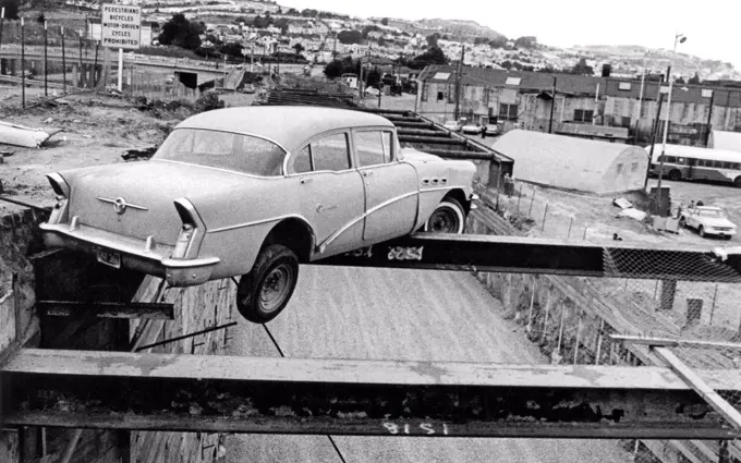 San Francisco, California:  June, 1969 A fortunate driver missed a turn and his car ended up precariously balanced on one of the BART roadway construction beams.