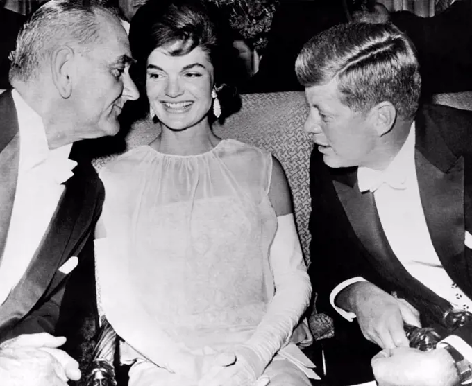 Washington, D.C.:   February 2, 1961 Vice President Lyndon Johnson leans over Jacqueline Kennedy to listen to President John Kennedy at the inaugural ball after their election to office.