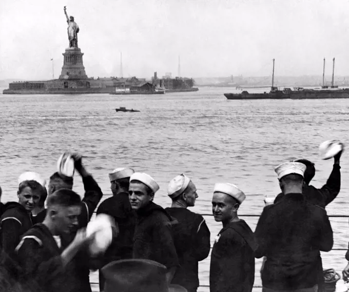 New York, New York:  May 1, 1920. Sailors on board the USS Pennsylvania cheer as they pass by the Statue of Liberty on their way to port in New York. It literally means liberty to them as they will be given shore leave when they finally anchor.